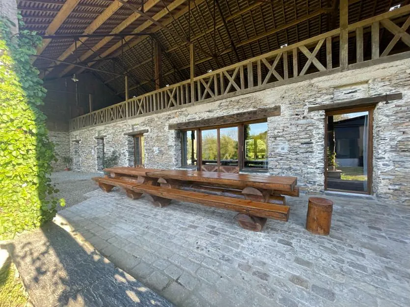 Le patio couvert de la longère du Repère de Choiseau, avec sa grande table en bois